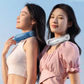 Two women wearing white and blue hands-free neck fans outdoors